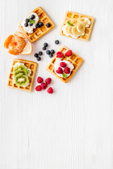 Breakfast with freashly baked belgian waffles on white background top-down frame copy space
