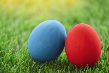 red and blue easter egg on lawn green grass artificial, concept image of morning in springtime