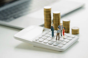 business accounting concept. miniature  toy meeting on calculator with money stack background