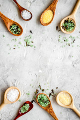 Colorful spa salt in spoons on grey background top-down frame copy space