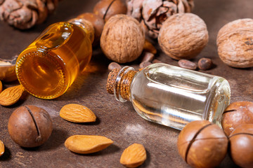 Natural Serums. Cosmetic and medicinal oil of macadamia, almonds, walnuts, pine nuts on a brown...