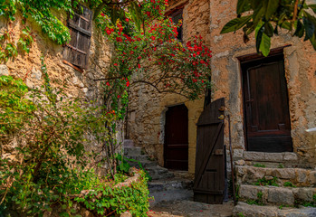 Old buildings with flowers in the streets of Eze Village, medieval city in South of France along the Mediterranean Sea
