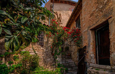 Fototapeta na wymiar Old buildings with flowers in the streets of Eze Village, medieval city in South of France along the Mediterranean Sea