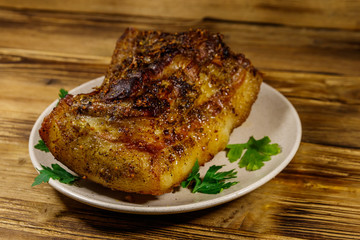 Baked pork belly in a plate on wooden table