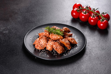 Chicken fillet in sesame seeds, teriyaki sauce on a black stone plate