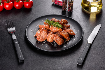 Chicken fillet in sesame seeds, teriyaki sauce on a black stone plate