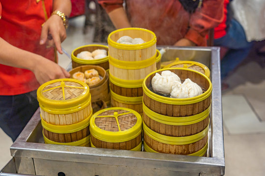 Waitress picking dimsum steamer box for customer in Chinese restaurant