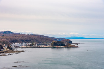 Fototapeta premium View of Utoro fishing port in springtime with Shiretoko mountain range at Utoronishi. Town Shari, Shiretoko Peninsula. Hokkaido, Japan