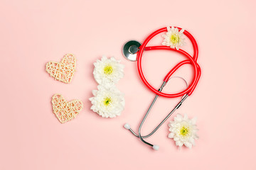 International Women's Day card with stethoscope, hearts and chrysanthemum flowers  in the form of eight on pink background.