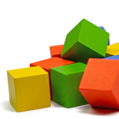 Bunte Holzbaukl&ouml;tze vor wei&szlig;em Hintergrund