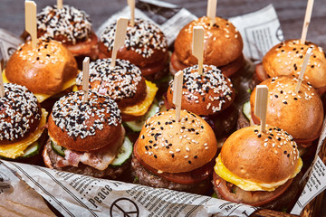 A large set of many hamburgers, cheeseburgers laid out on the table. Seth fast food. Food background, copy space.