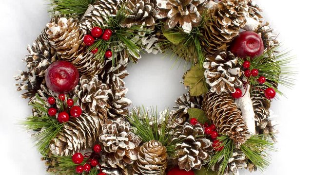Christmas wreath overhead rotating in a seamless loop on a snow white background