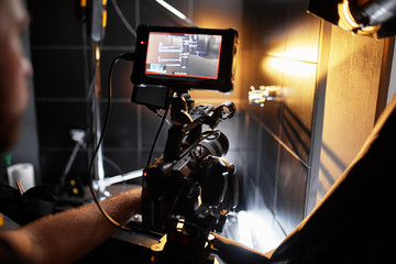 Video production backstage. Behind the scenes of creating video content, a professional team of cameramen with a director filming commercial ads. Video content creation, video creation industry. Low