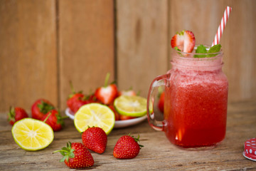 strawberry juice in glass on wooden background