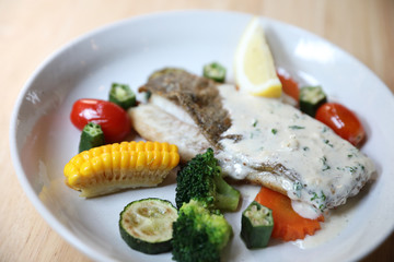 Sea bass fillet , baked sea bass with lemon sauce on wood background