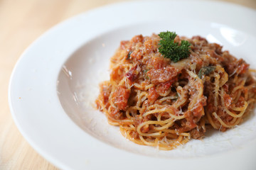spaghetti Bolognese with minced beef and tomato sauce garnished with parmesan cheese and basil , Italian food