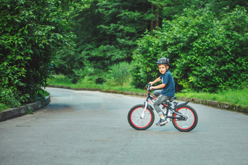Obraz premium little boy riding on bicycle in helmet