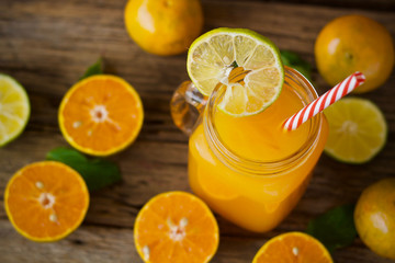 oranges and orange juice in glass on wooden table
