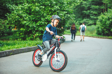 little boy riding on bicycle in helmet