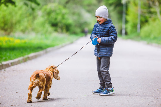 Little Kid With Small Brown Dog Running In City Park