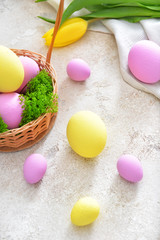 Basket with beautiful Easter eggs on light background