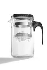 Subject shot of a clear glass teapot with a removable infuser and inlying strainer, a black handle and cover. The transparent jug is isolated on the white background.
