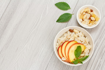 Sorghum salad with nuts and fresh peach on wooden background.