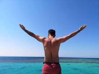  men's back against the backdrop of a water plexus of the sea, relax and high on the sea