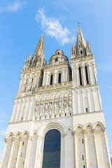 Fototapeta na wymiar Cathédrale Saint-Maurice, Angers, Maine-et-Loire, France. Beautiful vertical shot of the Cathedral angevin-gothic facade from a low-angle. Sunny day with a blue sky.