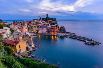 Fototapeta na wymiar Sunset view of Vernazza, one of the five Mediterranean villages in Cinque Terre, Italy, famous for its colorful houses and harbor
