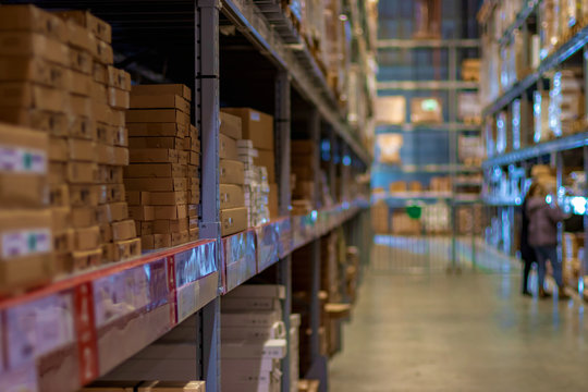 Modern warehouse with goods on folding metal shelves. Blurred, focus with shallow depth of field and bokeh.