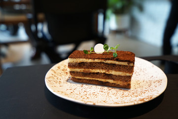 Close up dish of Tiramisu -Italian dessert made of Mascarpone custard layered with whipped cream ,rum and coffee soaked ladyfingers