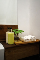 Rolled hand washing towels and cleaning gel bottles on wooden tray table