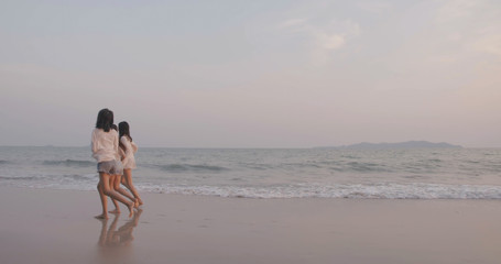 Smiling Happy asian friends women running together seaside on beach summer vacation sunset silhouette dusk holidays travel enjoy life weekend activity people lifestyle