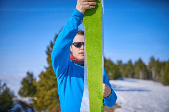 Man sticking climbing skins on splitboard in the snow. Ski touring equipment
