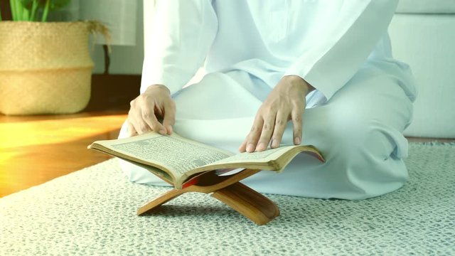 Portrait of Asian Muslim man reciting surah al-Fatiha passage of the Qur'an, in a daily prayer at home in a single act of sujud called a sajdah or prostration