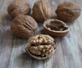 walnut with chopped shell and open kernel lies on a wooden background