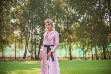 Spring natural romantic outfit, lady in pink coat at park