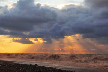 Obraz premium Sunset over sea with dramatic sky sky, dark storm clouds, and red light.