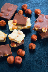 Dark and white chocolate with hazelnuts on a blue background