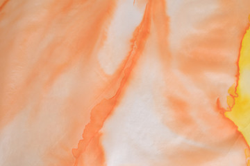 Fototapeta na wymiar close up of hand colored orange and yellow silk scarf