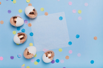Cute light blue background with gilded eggs and confetti.