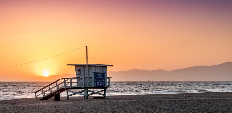 Sunset on the beach in California, Coast Guard rescue shed - Powered by Adobe