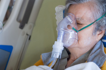 Close-up of elderly woman patients with lung disease, getting oxygen for treatment in the room at...