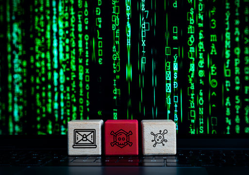 Computer cyber hacker concept with wooden blocks and malware, virus and black hat hacking icons - State sponsored security terrorism warfare attack with lines of ransomware code on laptop screen