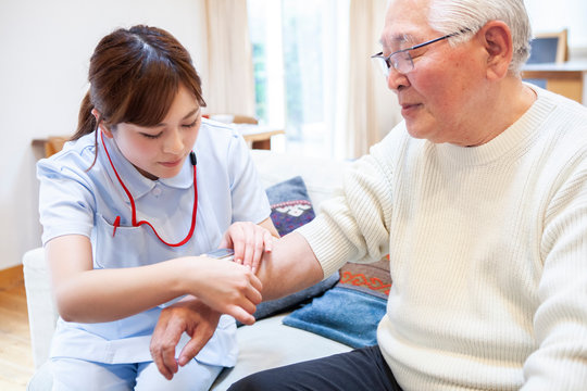 血圧を測る看護師