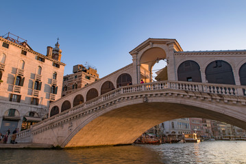 Rialto Bridge (Ponte de Rialto) across Grand Canal at sunrise / sunset time, Venice, Italy - obrazy, fototapety, plakaty