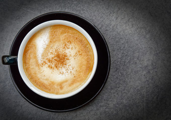 cappuccino coffee cup top view on grey table with space for text, filtered image