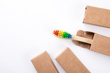 Bamboo toothbrush in a cardboard packaging with copy space on a white background