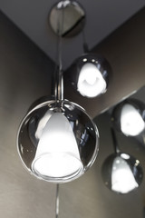 Ceiling light. Modern three-lamp chandelier. Lamp in the bathroom. Reflected in the mirror.